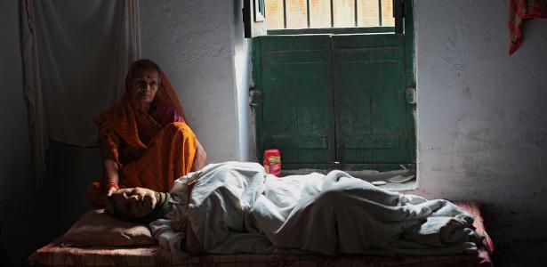 Mulher deitada na cama do hotel Mukti Bhawan em Varanasi, na Índia