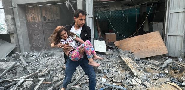 Menina palestina é retirada de casa atingida por míssil israelense no campo de refugiados de Jabalia, no norte da Faixa de Gaza