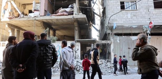 Palestinos inspecionam os danos no local de um ataque israelense no bairro de Sheikh Radwan, na Cidade de Gaza, em 15 de dezembro de 2024