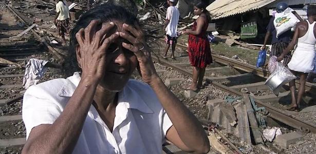 Uma mulher do Sri Lanka chora em frente à sua casa destruída na área costeira de Colombo, em 26 de dezembro de 2004, quando ocorreu o tsunami