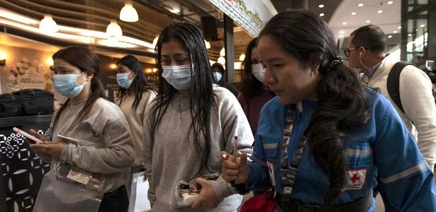Colombianos são recebidos por membros da Cruz Vermelha ao chegarem no Aeroporto Internacional de El Dorado, na Colômbia, após deportação dos EUA