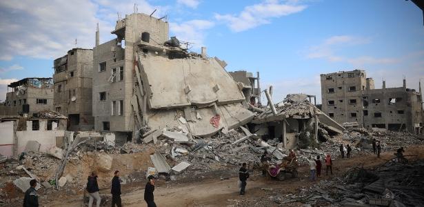 Palestinos inspecionam a destruição ao retornar a Nuseirat, no centro da Faixa de Gaza, após o bombardeio israelense ao campo ter parado em 29 de novembro de 2024