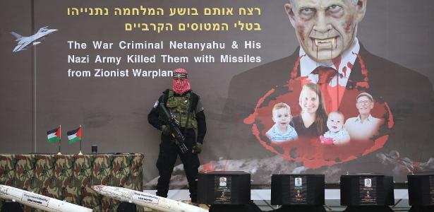 Retrato alterado do primeiro-ministro de Israel e da família Bibas, no palco antes da entrega dos corpos de quatro reféns israelenses pelo Hamas