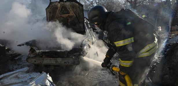 7.mar.2025 - Bombeiro apaga fogo em carro após um ataque russo em Kharkiv durante a noite