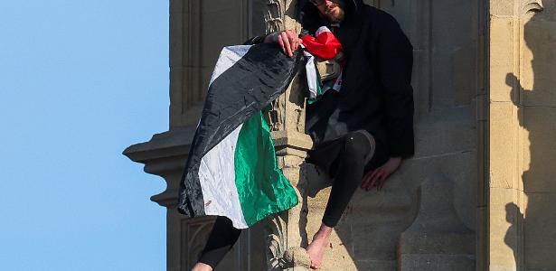Homem com bandeira da Palestina sentado no topo da torre Big Ben de Londres