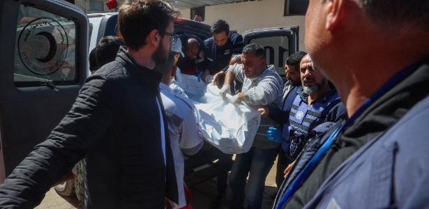 19.mar.2025 - Corpo de funcionário da ONU morto após ataque israelense é transportado na Faixa de Gaza