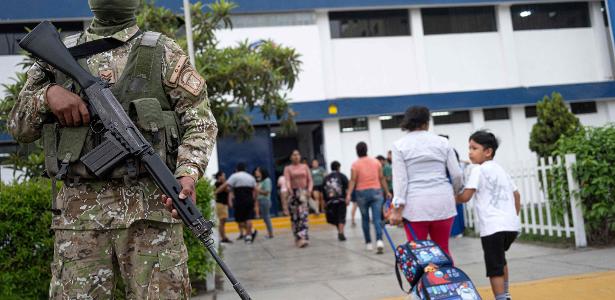 Membros do exército peruano montam guarda enquanto pais deixam seus filhos na escola particular San Vicente, que foi vítima de extorsão, em Lima