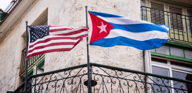 Bandeiras dos EUA e de Cuba lado a lado em sacada de apartamento em Havana