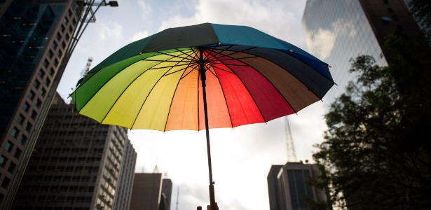 9.jun.2012 - Participante de caminhada ergue guarda-chuva colorido com as cores da bandeira do movimento gay. Realizada desde 2002, a caminhada tem como objetivo protestar contra o preconceito a diversidade sexual
