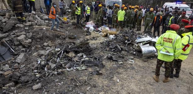 Equipes de resgate ao lado dos destroços de um local onde um avião médico queniano caiu, matando pelo menos seis pessoas, nos arredores de Nairóbi, em 7 de agosto de 2025