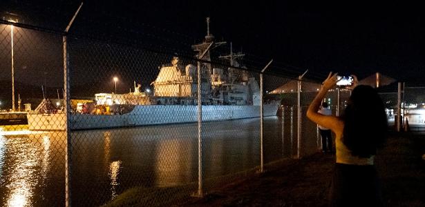 Mulher tira fotos enquanto o navio de guerra USS Lake Erie, da Marinha dos EUA cruza Canal do Panamá durante uma mobilização naval dos EUA perto da costa da Venezuela, na Cidade do Panamá
