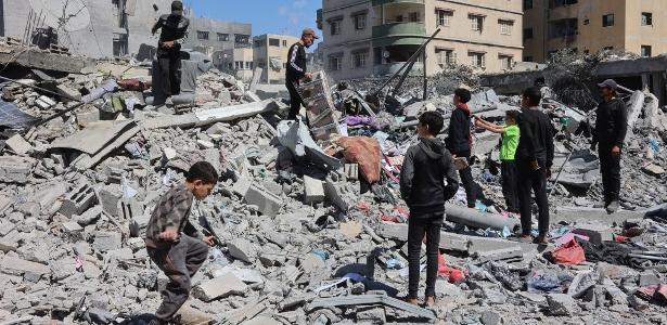 19.mar.2025 - Palestinos inspecionam os escombros de uma casa após ela ser destruída em um ataque israelense na Cidade de Gaza