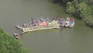 Boat of fishermen with track against oil exploration in the Amazon
