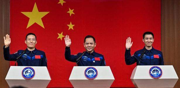 Os astronautas da missão espacial chinesa Shenzhou-21: Zhang Hongzhang, à esquerda, o comandante Zhang Lu, no centro, e Wu Fei à direita, durante uma coletiva de imprensa antes do lançamento da missão na China